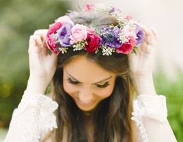 Bride wearing a purple and pink flower crown made of anemones and roses