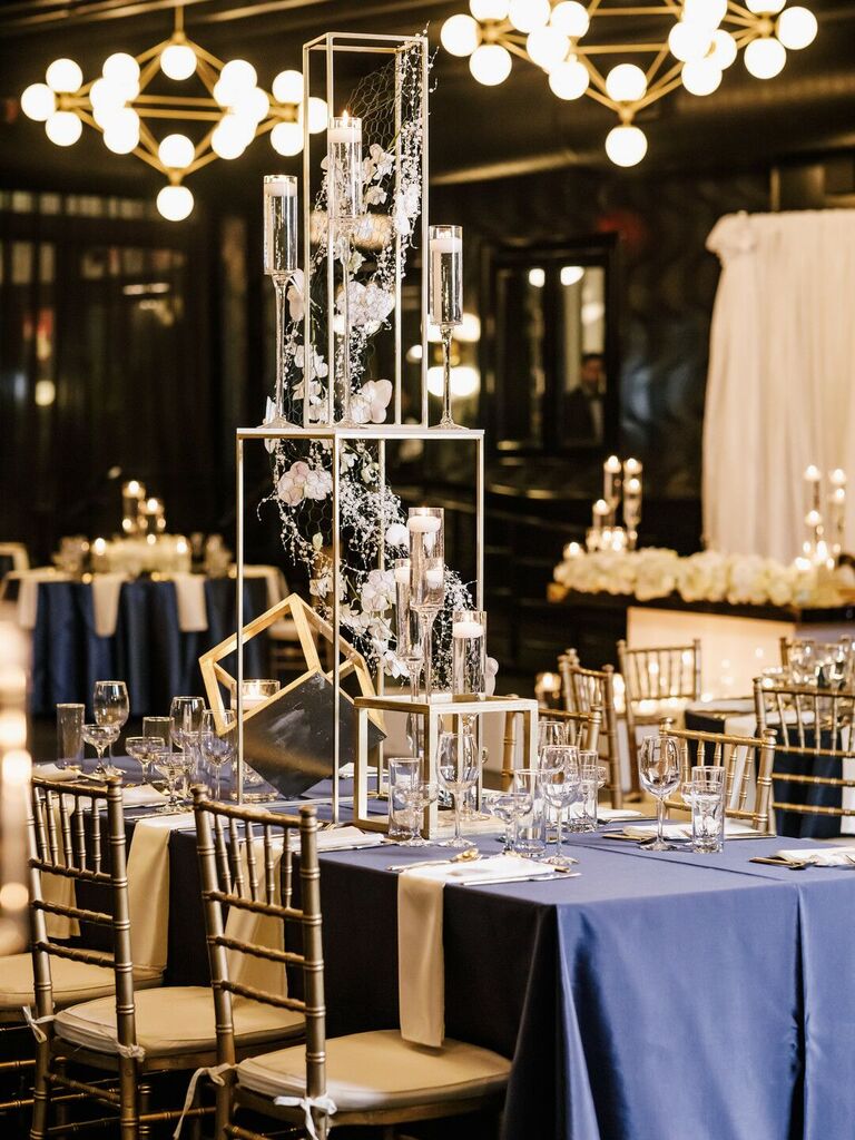 tall wedding centerpiece featuring three-tier geometric silver stand decorated with floating candles and flowers attached to wire