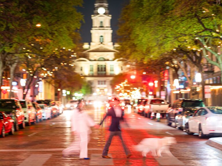 Blurry photo of a couple and their dog at night. 