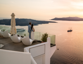 Couple standing on terrace at sunset in Greece