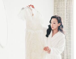 Bride in robe looking at wedding dress