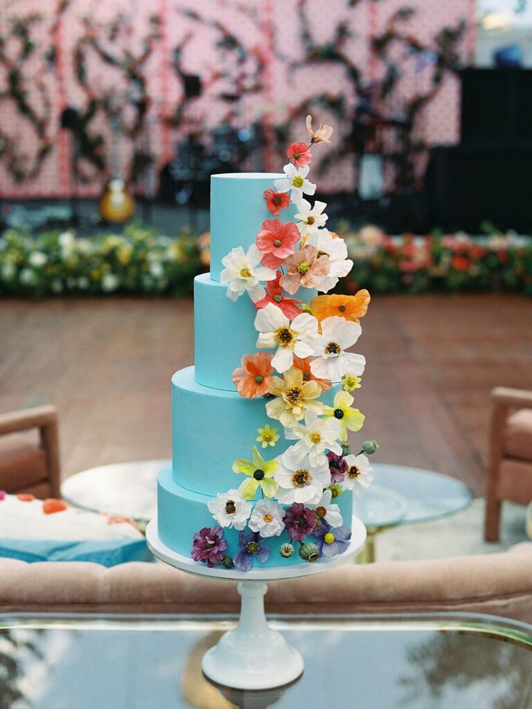 turquoise wedding cake decorated with yellow, orange, pink, white and purple flowers