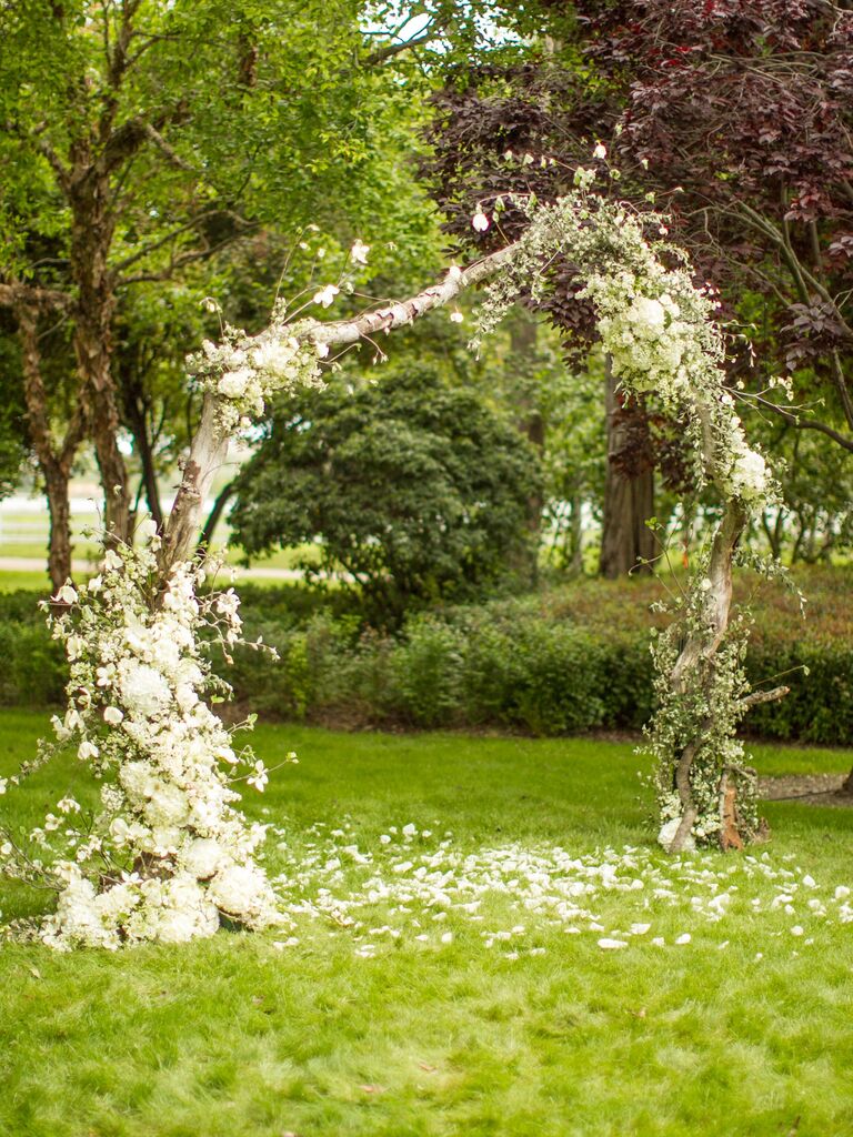 outdoor wedding ceremony arch made from birch branches decorated with white flowers
