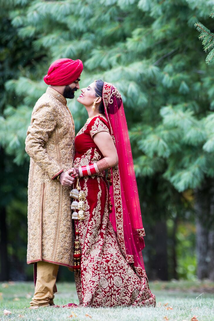 Indian Couple In Traditional Red And Gold Wedding Outfits