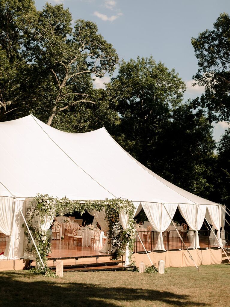 Sailcloth tent with greenery arch entryway