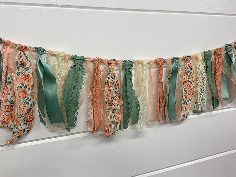 Hanging ribbon garland with green and pink color palette, floral and lace details