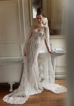 Chantilly lace cascades into a flared skirt that skims the floor, establishing the base gown of Livia. Crafted by WONÃ Concept for the White line, this design features an open sweetheart neckline and a sculpted upper bodice with exposed detailing at the natural waist. A classic court train follows every movement. For a striking visual shift, an ivory lace cape layers over the shoulders. This transformable piece alters the open silhouette into a covered, sleeveless high-neck configuration. Classic floral motifs interplay with modern lines throughout the ivory and original textiles. Livia offers a fluid transition between an open gown and a covered, regal silhouette.