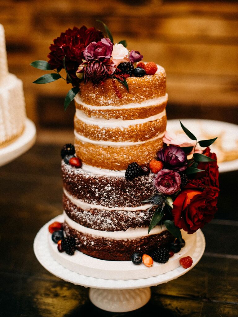 Naked rustic wedding cake with dark red flowers