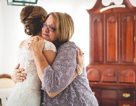 A bride and her mother share a tender moment together on the big day.