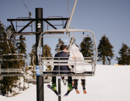 Bride and groom on ski lift 