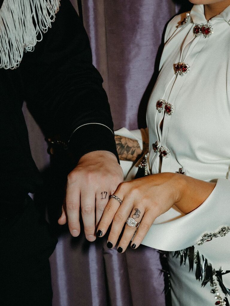 bride and groom show off new wedding tattoos on their ring fingers at las vegas elopement