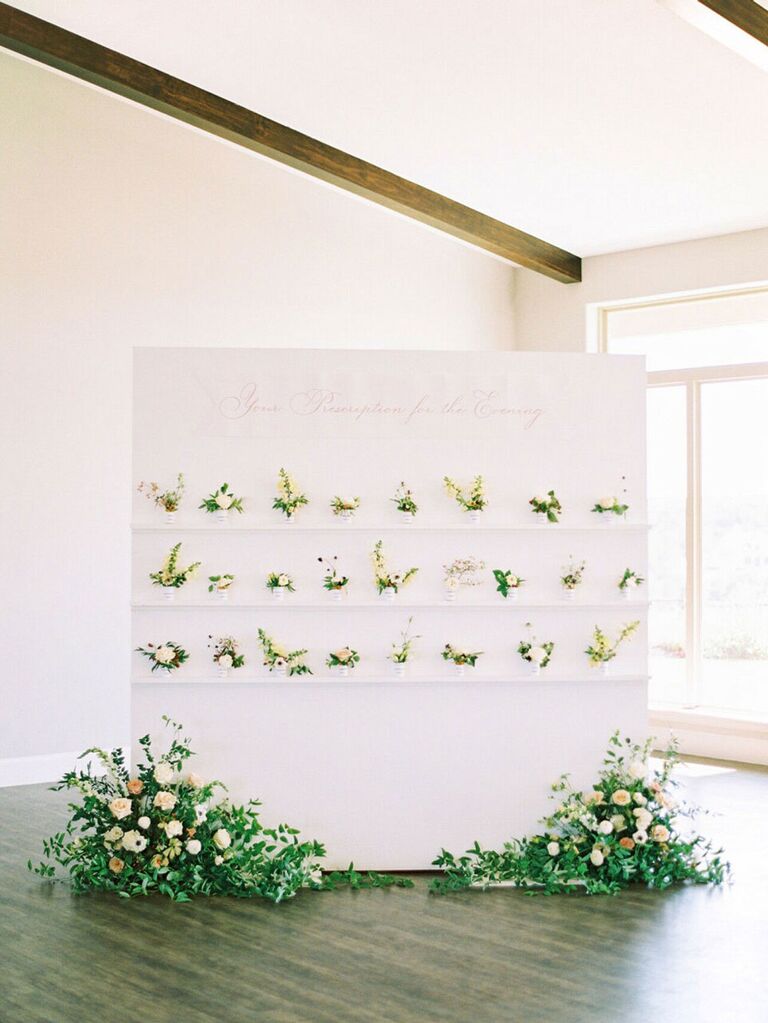 Sleek escort card display with fresh flowers at summer wedding reception