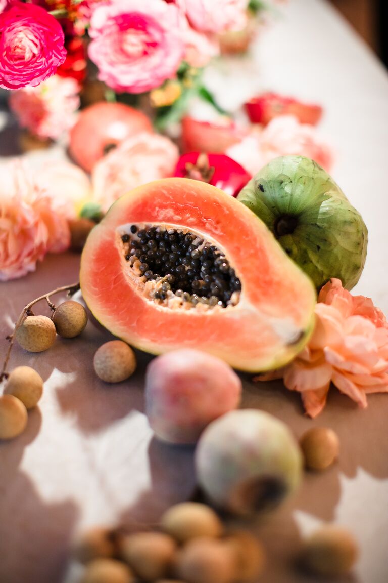 closeup of fresh fruit wedding reception centerpiece sliced papaya and pink flowers 