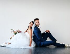 Wedding couple sitting down, smiling for the camera