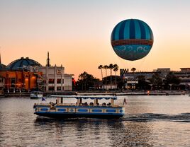 Panoramic view of Disney Springs and water taxi on colorful sunset background at Lake Buena Vista area