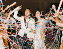 Couple existing wedding surrounded by streamers