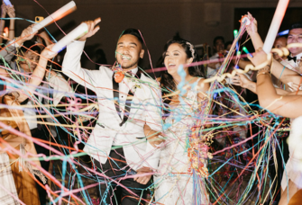 Couple existing wedding surrounded by streamers