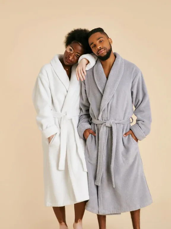 Couple wearing matching cozy bathrobes in white and gray