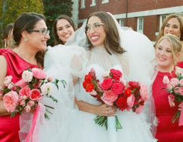 Bride with glasses smiling at bridesmaids