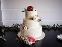 white three tier buttercream wedding cake with pink and white flowers