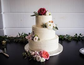 white three tier buttercream wedding cake with pink and white flowers