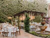 Whimsical garden bridal shower venue with hanging bistro lightng and stone water fountain