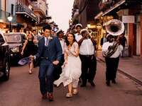 Happy couple dancing through the street with a brass band