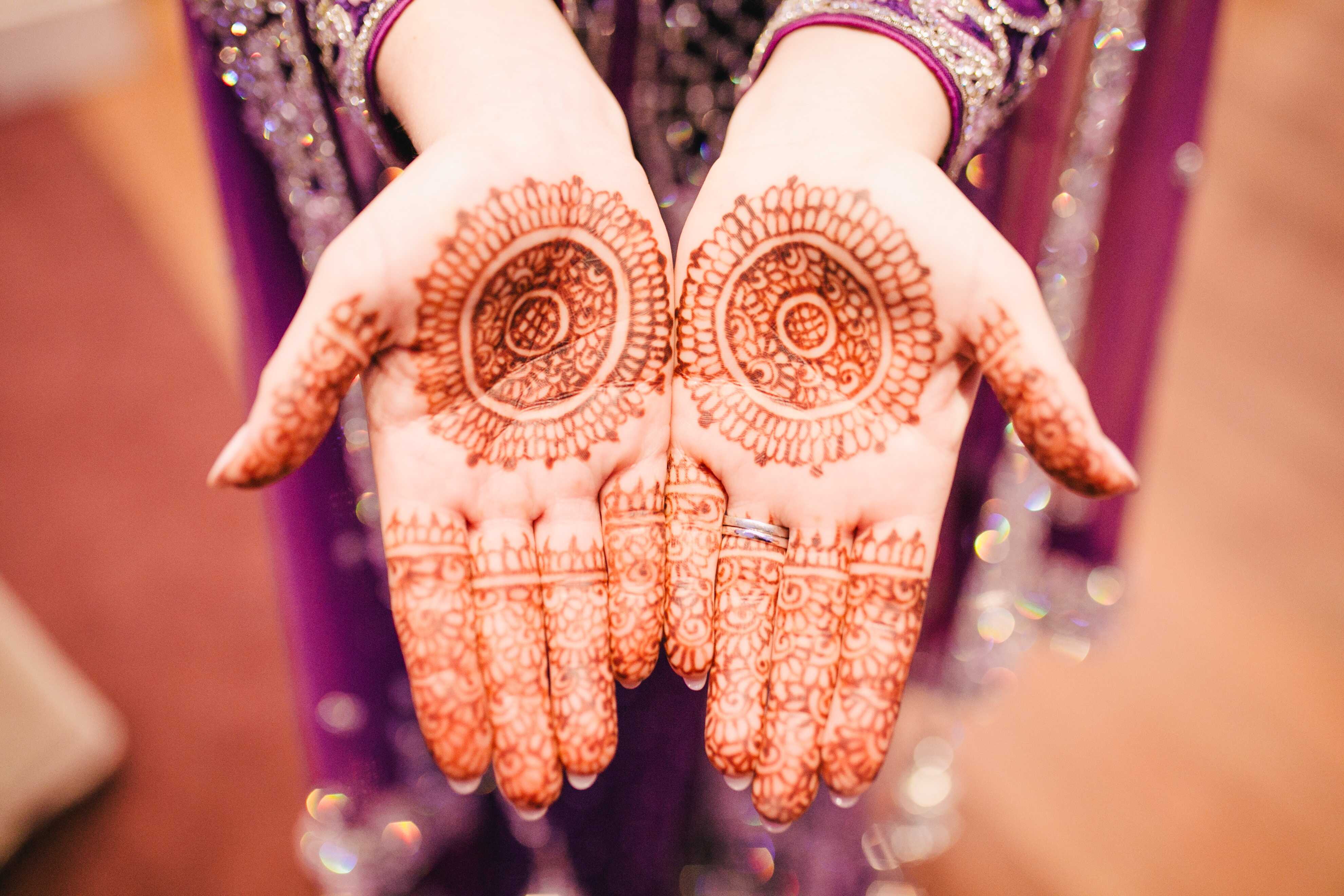Intricate henna tattoo designs on the palms of a woman’s hands