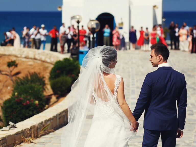 Couple outside the church on the day of their wedding on the island of Santorini, Greece