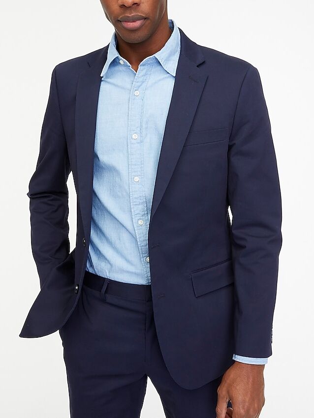 Model wears a sleek fitted suit jacket. 