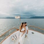Bride and groom sitting on boat at destination wedding