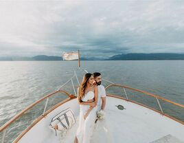 Bride and groom sitting on boat at destination wedding