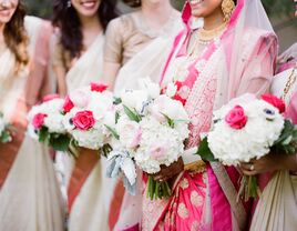 Bridesmaids and a bride holding white and pink bouquets.