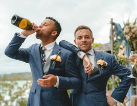 Grooms drinking champagne on wedding day