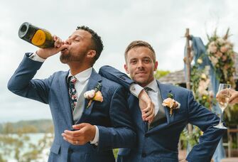 Grooms drinking champagne on wedding day