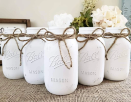 White distressed mason jars with rope bow detail for wedding favors