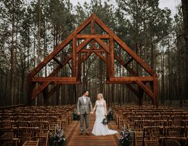 Couple holding hands in a forest ceremony site