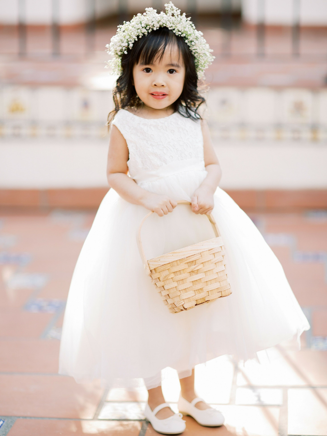 Flower girl in white dress with basket and flower crown