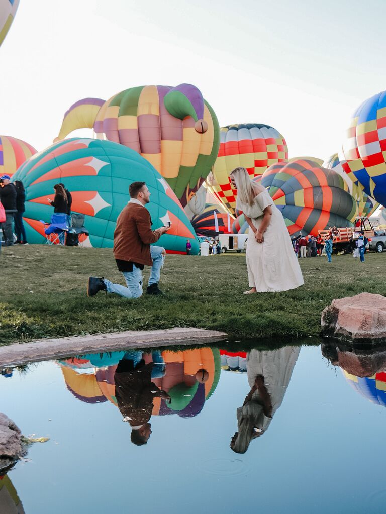 Romantic couple proposal in the middle of hot air balloon field