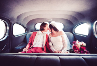 Couple toucjing noses sitting in back of limo on wedding day