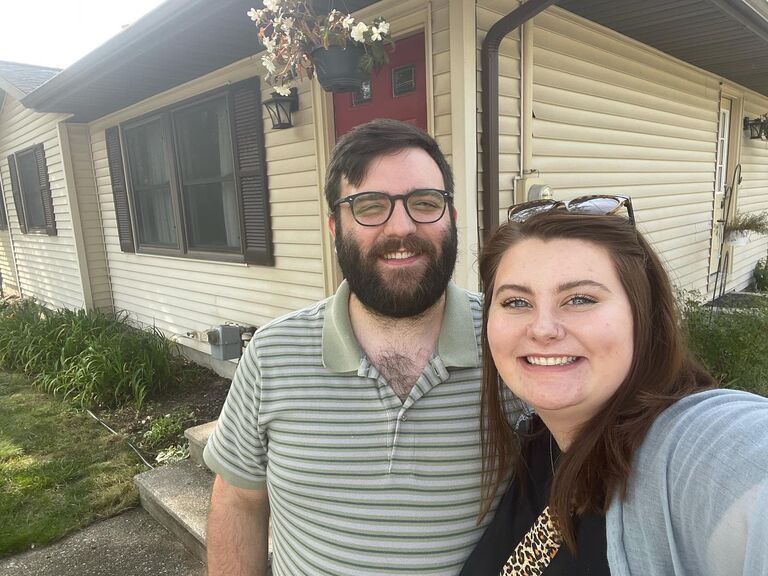 First-time homeowners outside of their new home in Portage- the doors are now painted purple! (Tons of change happened inside too!)