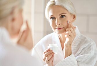 Mature woman applying face cream