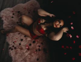 Boudoir photo of woman in red lingerie surrounded by rose petals by Kerstee Ashlee Photography in Utah