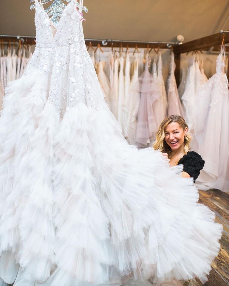 Hayley Paige posing with one of her wedding dresses