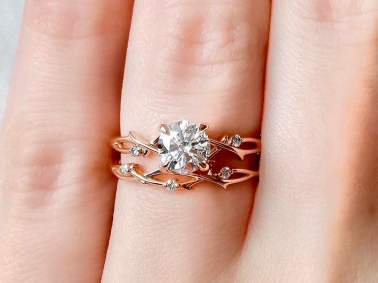 Round center moissanite with small diamonds on twisted twig rose gold bands