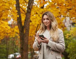 Woman on her phone during the fall season