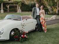 Couple leaning on vintage car for engagement photos