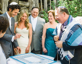 Bride and groom signing their ketubah at their wedding. 
