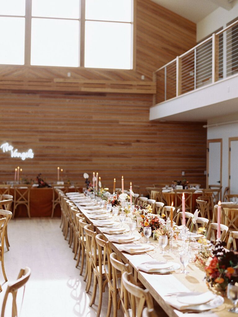 Barn wedding reception venue with retro boho centerpieces and custom neon sign