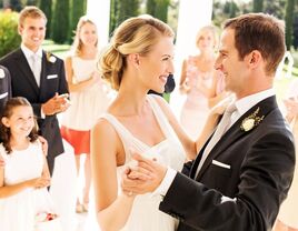 Couple during their romantic first dance while guests watch